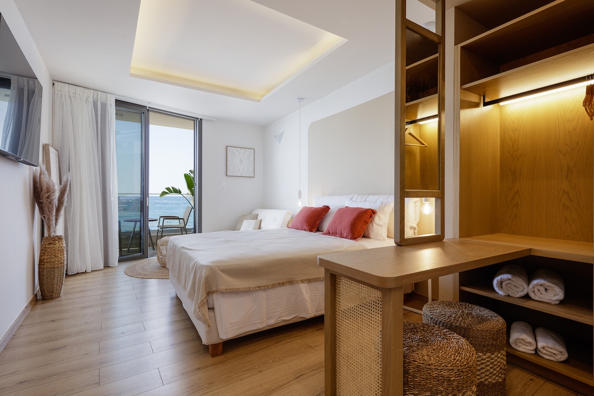Luxury Sea View Studio with a bed, wood shelving and balcony doors