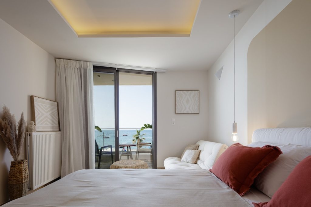 A bright bedroom opening towards the sea