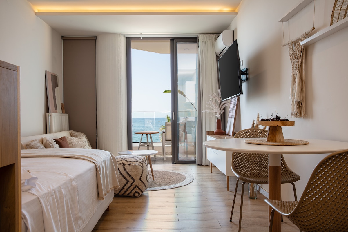Modern Sea View Studio with dining table, bed and sea-facing balcony