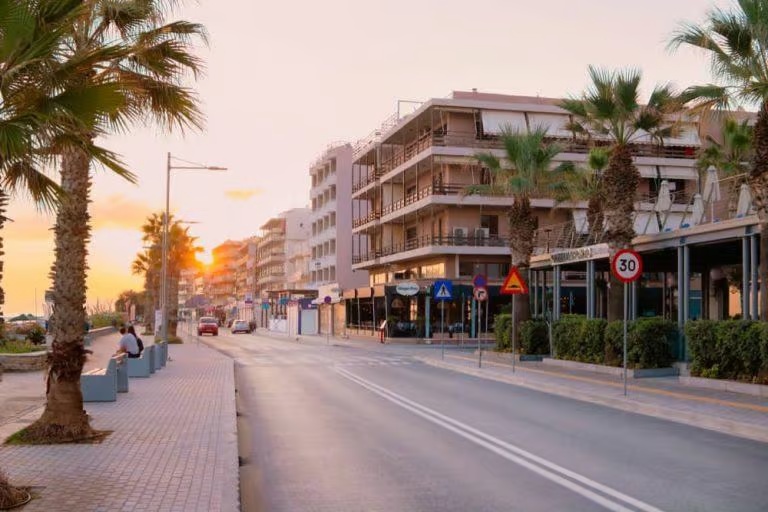 Rethymno seafront road and palm trees at sunset